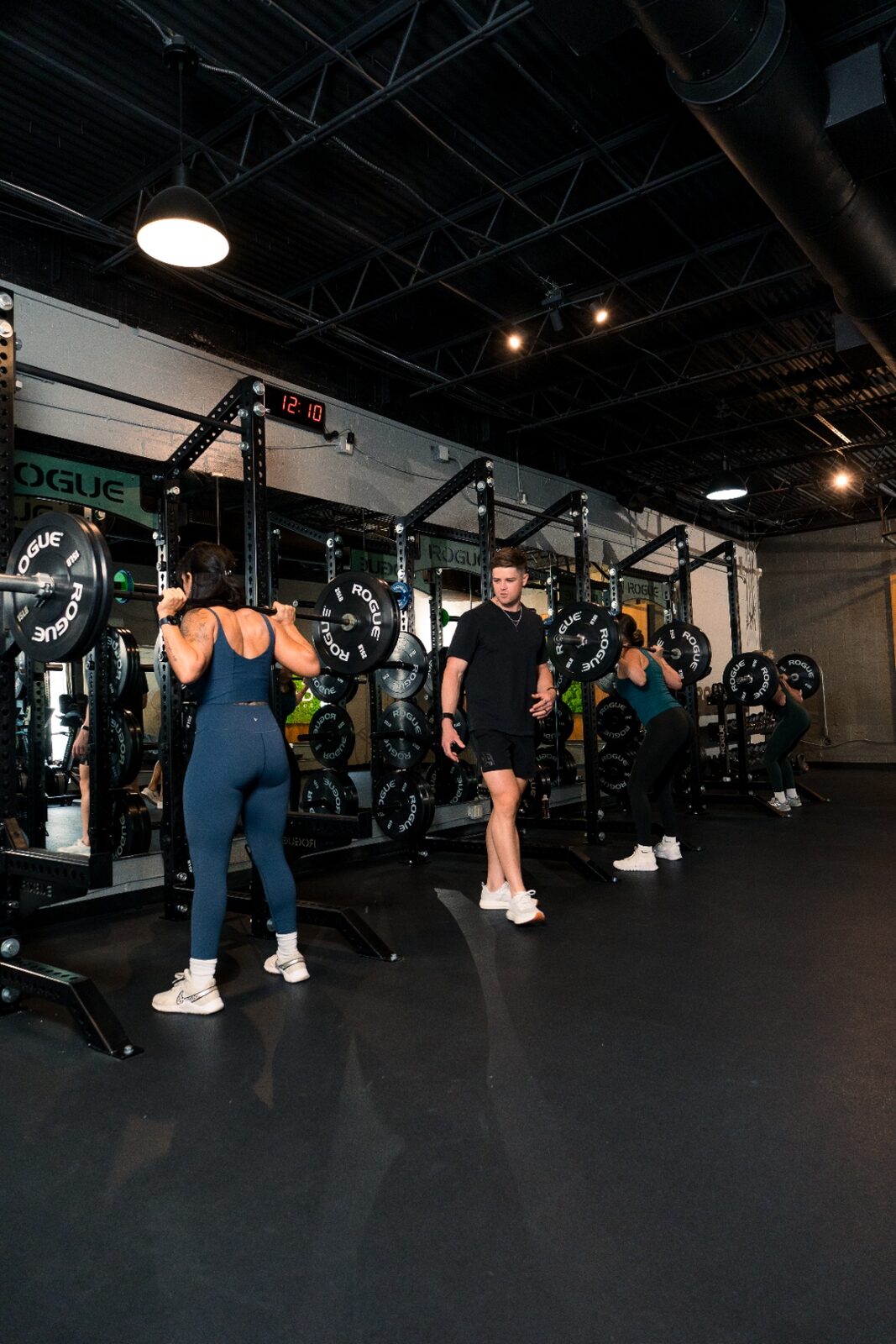 Group strength session at the squat racks